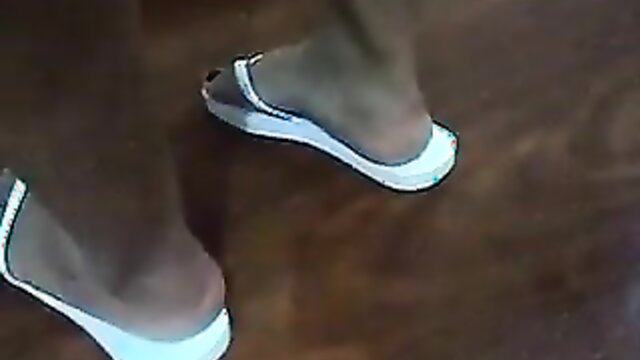 Latina feet in white flip flops flop around in mobile video