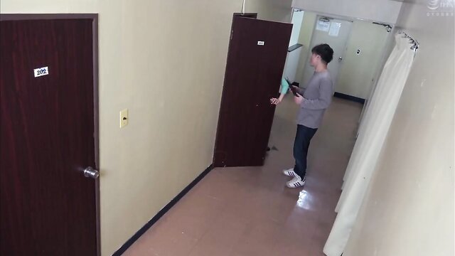Asian hot wife gives a blowjob in the hallway of her apartment while her husband is in the next room