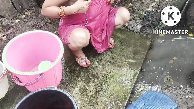 Indian housewife washing clothes and boobs in a public park